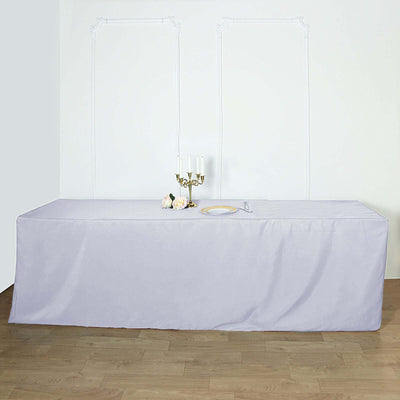 Purple table cover draped over a long table with candles and flowers.