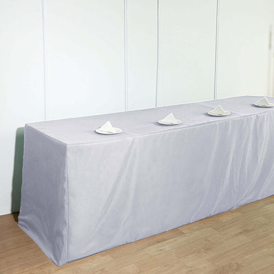 Gray table cover with neatly arranged napkins on a plain backdrop.