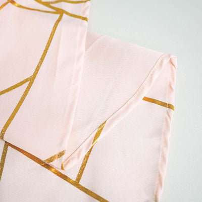 Pink fabric with gold geometric patterns folded neatly.