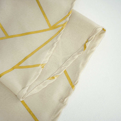 Cream fabric with gold geometric pattern folds.