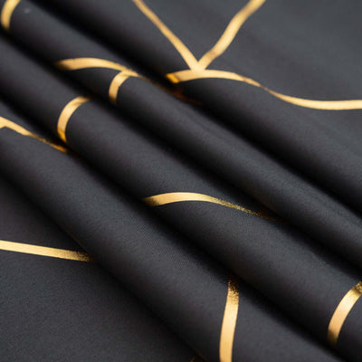 Black fabric with gold abstract lines, elegantly folded.
