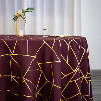 Maroon tablecloth with gold geometric pattern on a round table.