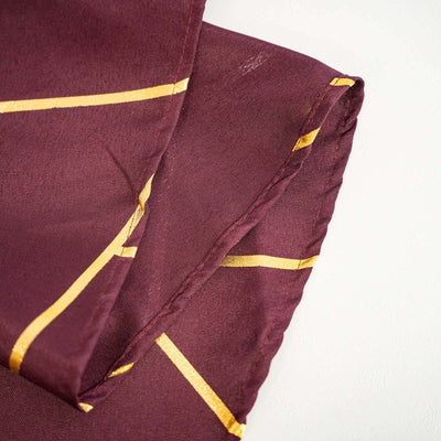 Burgundy silk scarf with gold geometric pattern folds