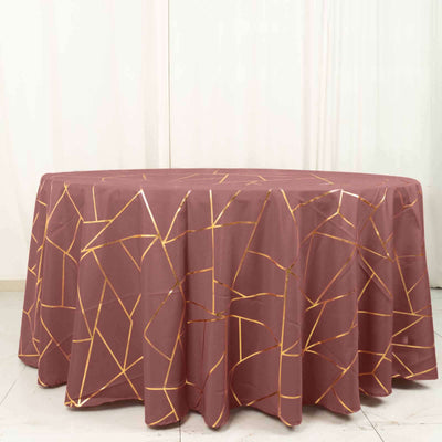 Round tablecloth with a geometric gold design on a maroon background.