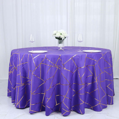 Purple tablecloth with gold geometric pattern on a round table.