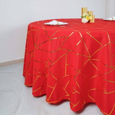 Red tablecloth with gold geometric pattern on a round table.