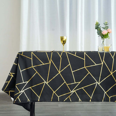Geometric black tablecloth with gold accents on a table setting.