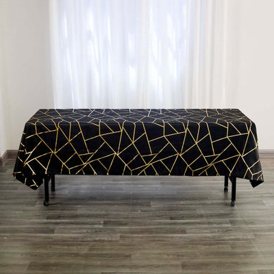 Black tablecloth with gold geometric pattern on a table.