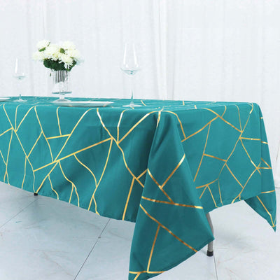 Teal tablecloth with gold geometric pattern on a dining table.