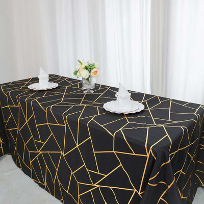 Elegant black tablecloth with gold geometric pattern, set for dining.