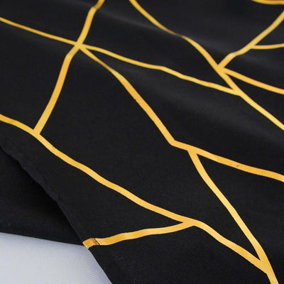 Black fabric with gold geometric patterns for stylish decor.