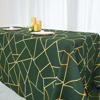 Green tablecloth with gold geometric pattern on a dining table.