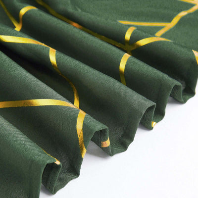 Green fabric with gold geometric pattern, showcasing elegant draping.