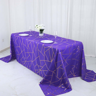 Purple geometric tablecloth on a dining table with plates and glasses.