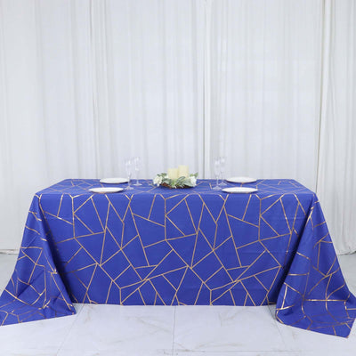 Blue geometric tablecloth with gold accents on a table setting.