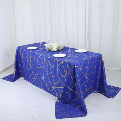 Blue geometric tablecloth with gold accents on a dining table.
