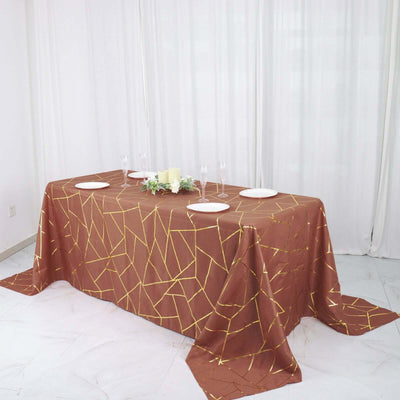 Brown geometric tablecloth with gold accents on a dining table setting.