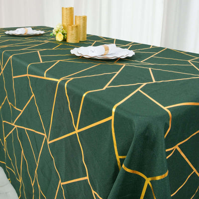 Green tablecloth with gold geometric pattern, styled for an elegant table setting.