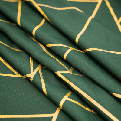 Green fabric with gold abstract lines, showcasing texture and design details.