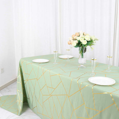 Green geometric tablecloth with gold accents on a dining table.