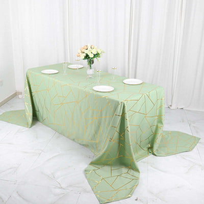 Geometric patterned mint green tablecloth with gold accents on a dining table.