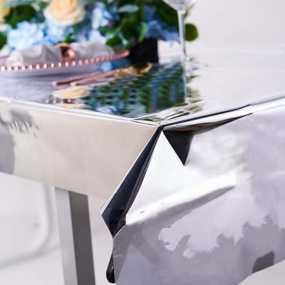 Shiny silver table cover with a reflective surface and folded corner.