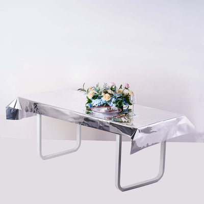Silver table cover with floral centerpiece on a table.