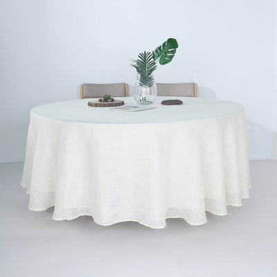 Round cream tablecloth on a dining table with decor