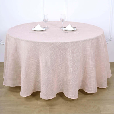 Round pink tablecloth draped elegantly over a circular table with glassware and napkins.