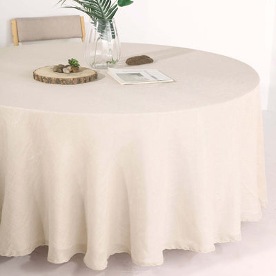 Round beige tablecloth draping a table with a minimalist setting.