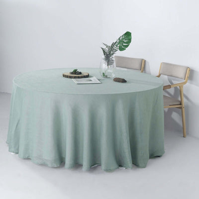 Round mint green tablecloth on a table with chairs and decor.
