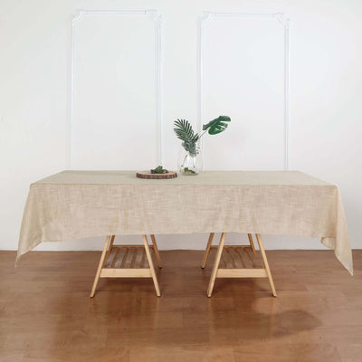 Table with beige tablecloth and decorative plant in vase