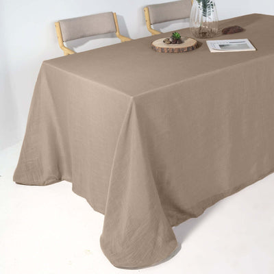 Beige linen tablecloth draped over a dining table with minimalist decor.