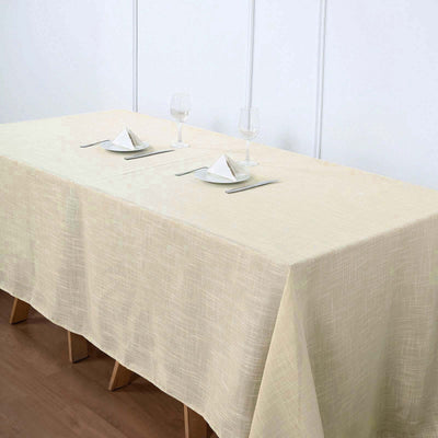 Cream tablecloth draped over two tables set for dining with glasses and napkins.