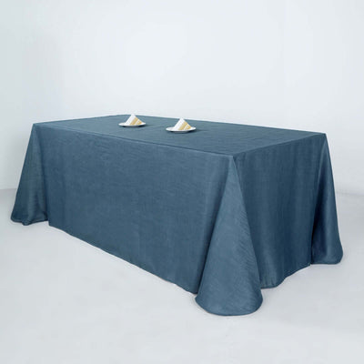 Blue linen tablecloth draped over a table with two plates on top.