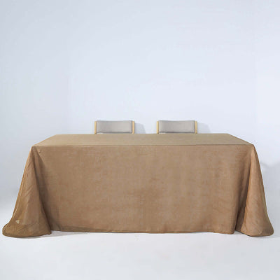 Brown tablecloth draped over a table with two chairs in a studio setting.