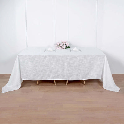 White tablecloth draped over a table with floral centerpiece