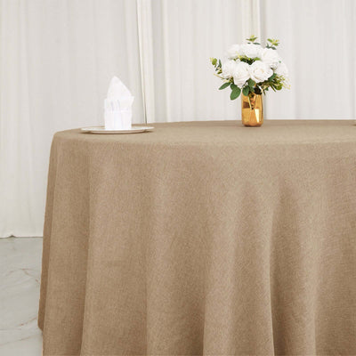 Brown textured tablecloth on a dining table with a vase of white flowers.