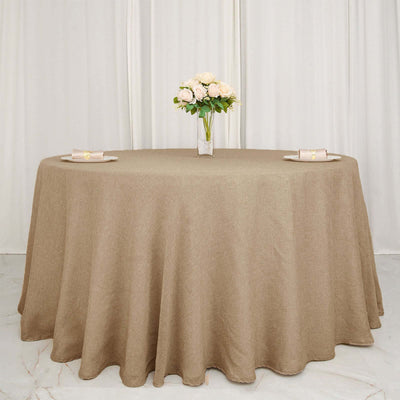 Round brown tablecloth on a dining table with a vase of flowers.
