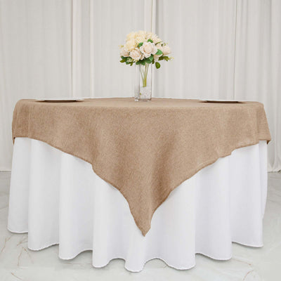 Brown tablecloth draped over a white table with a vase of flowers on top.