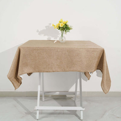 Brown linen tablecloth draped on a table with a vase of flowers.