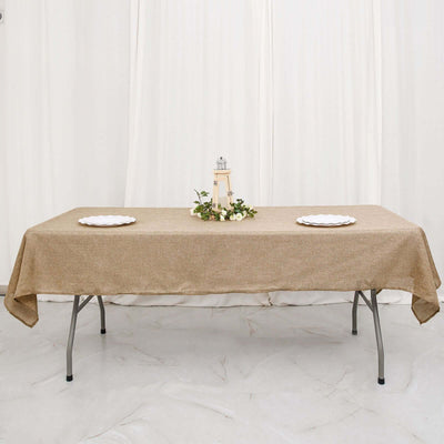 Table set with a burlap tablecloth, decorative lantern, and floral centerpiece