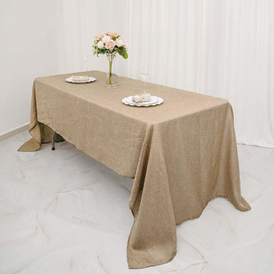 Linen tablecloth draped over a table with flowers and plates