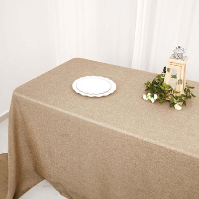Brown textured tablecloth on a table with a plate and decorative lantern.