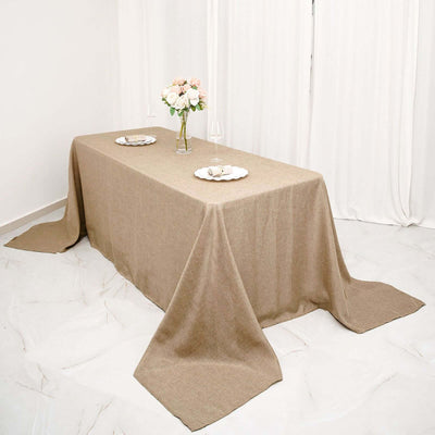 Elegant beige tablecloth draped over a dining table with floral centerpiece.