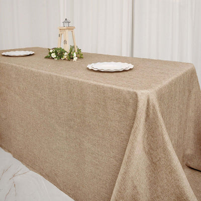 Natural linen tablecloth draped over a table with decorative plates and centerpiece.