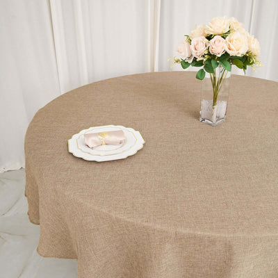 Round brown tablecloth with elegant plates and floral centerpiece.