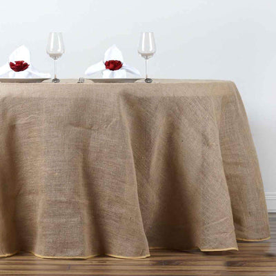 Burlap tablecloth draped elegantly over a dining table with wine glasses and napkins.
