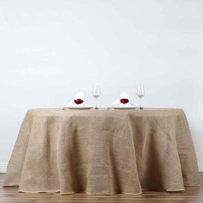 Elegant burlap tablecloth draped over a table with wine glasses and napkins.