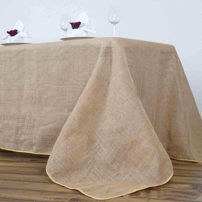 Linen tablecloth with yellow trim draped on a wooden table